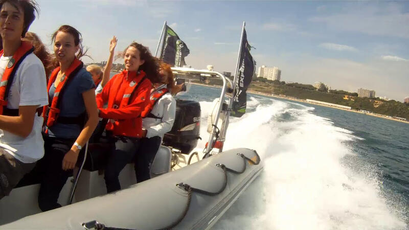 Jongeren zitten in een speedboat op vakantiekamp