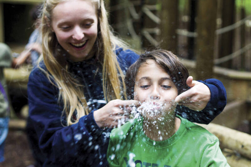 Jongetje proest op game kamp lachend water uit