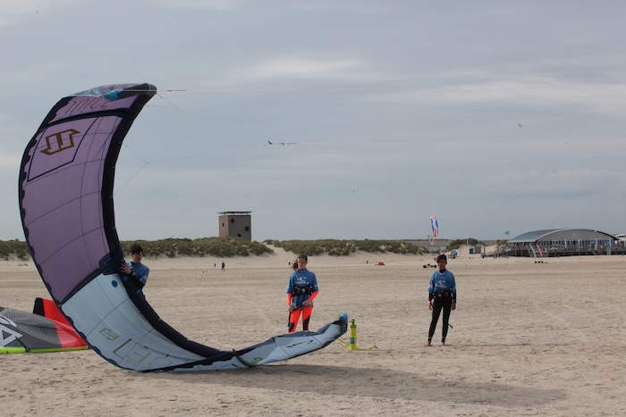 Jongens op het strand leren kitesurfen op kitesurf kamp Nederland