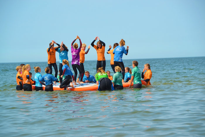 Met andere deelnemers en begeleiders van surfkamp zeeland activiteiten doen op het water