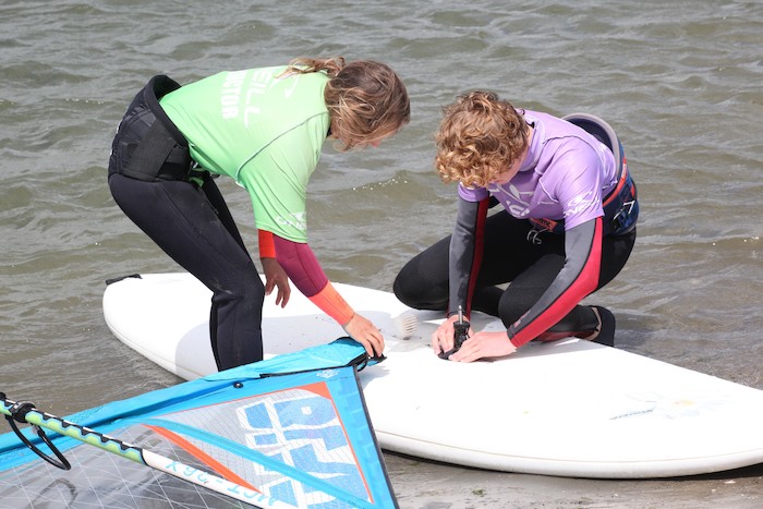 Kinderen zijn bezig met de voorbereiding voor het windsurfen