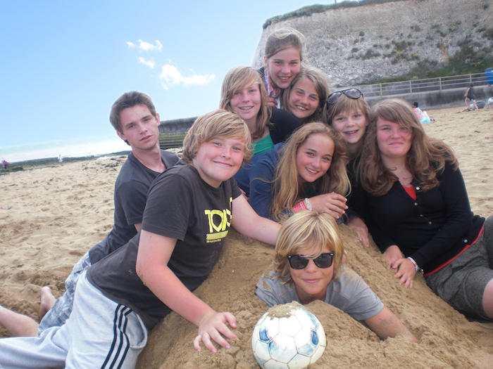 Kinderen liggen op het strand in de zand in Engeland