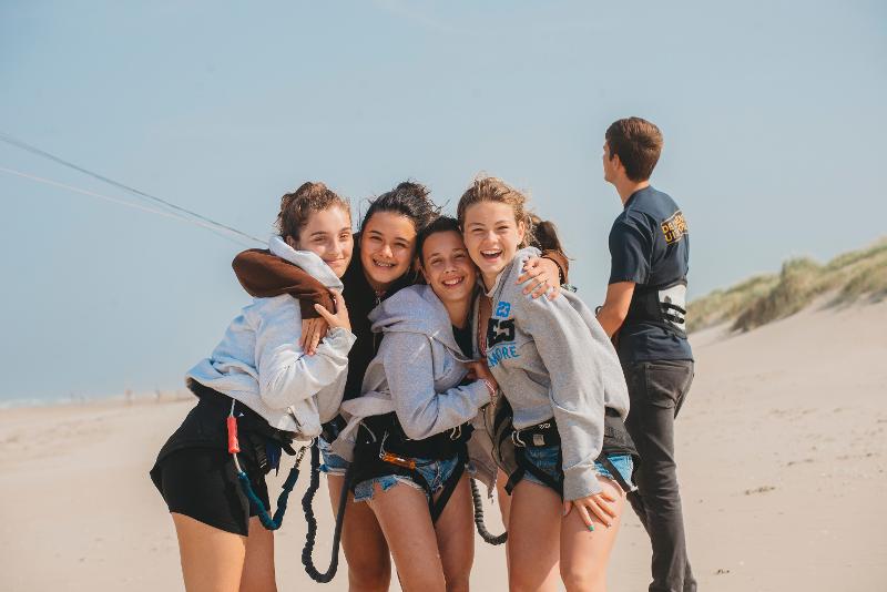 Meiden genieten van hun windsurfvakantie tijdens hun jongerenreis surfen