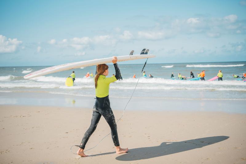Meisje met surfboard tijdens kinderkamp in Nederland 