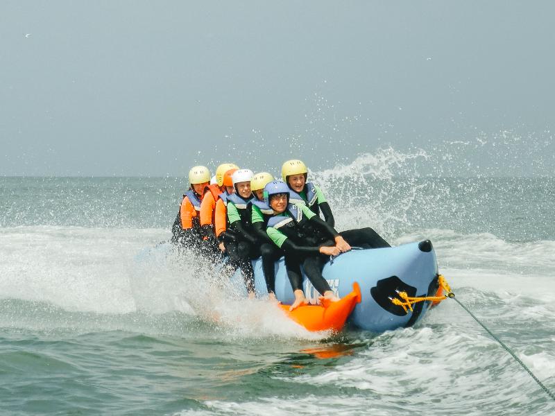 Kinderen zitten op een waterbanaan tijdens watersportkamp Nederland