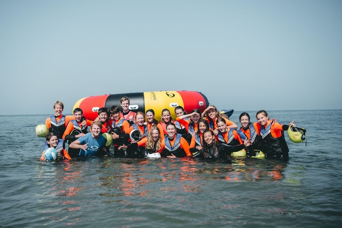 Groepsfoto in het water op watersport vakantie 