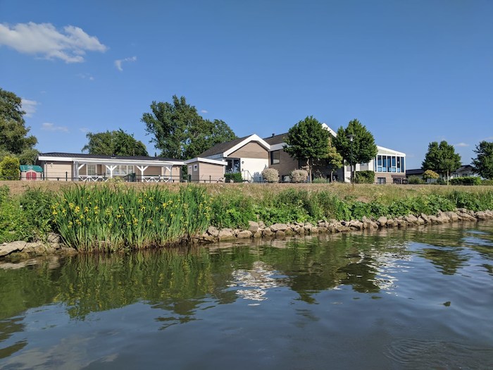 aanzicht van de accommodatie vanaf het water op watersport kamp in de biesbosch