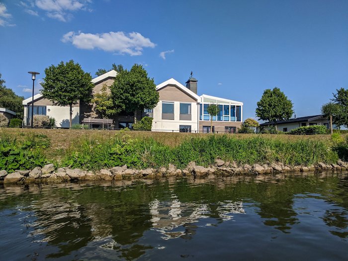 aanzicht van de accommodatie vanaf het water op watersport kamp in zuid-holland