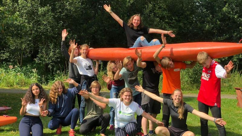 Jongens en meiden gaan op de foto tijdens kano kamp