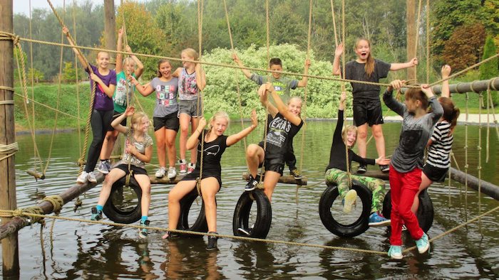 Jongens en meiden zijn aan het klimmen op  kano kamp