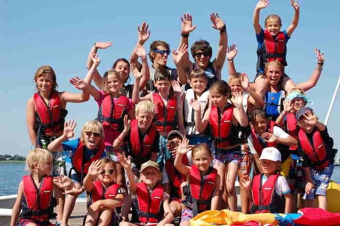 Photo de groupe d'enfants avec gilets de sauvetage en colonie de vacances voile