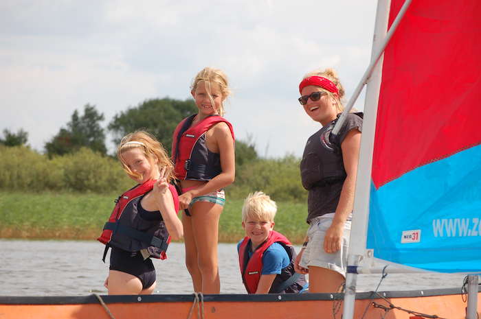 enfants avec l'animateur sur le bateau en colonie de vacances voile