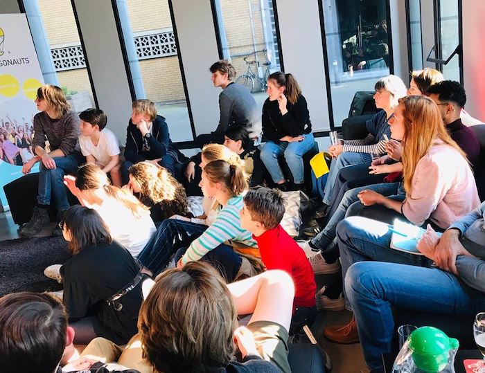 Jongeren luisteren naar presentatie op vakantiekamp gent