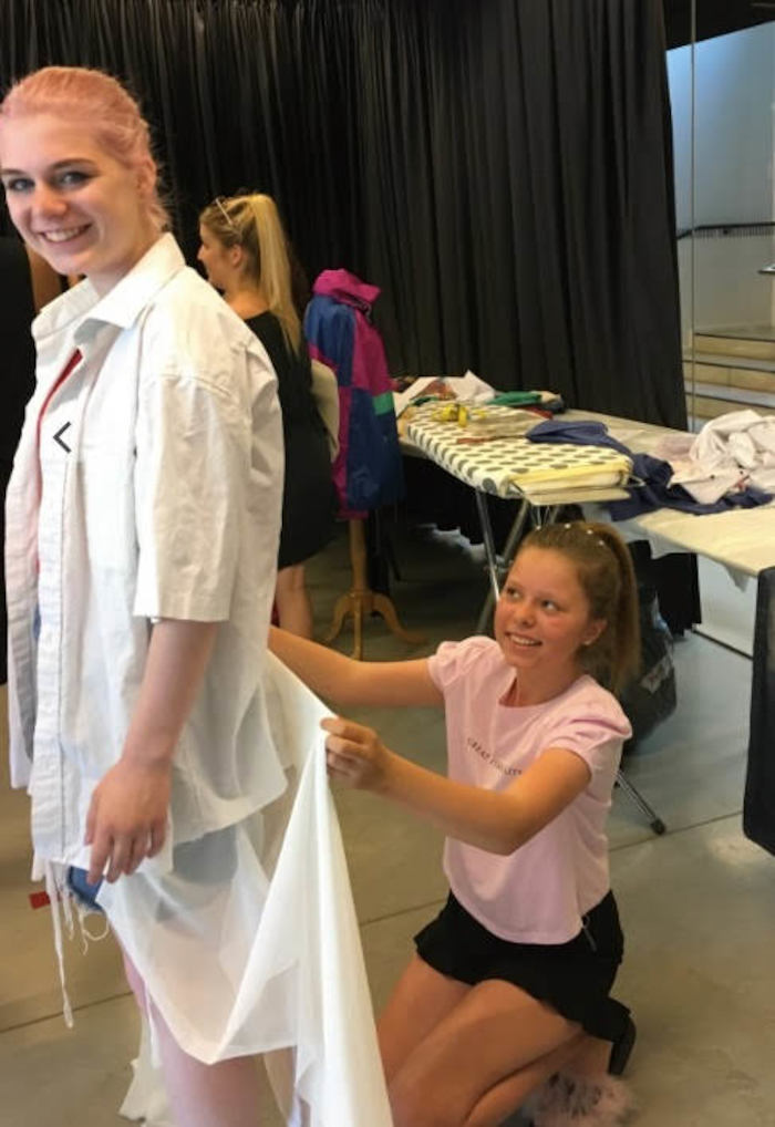 Meisjes passen en verstellen kleren tijdens het fashion zomerkamp.