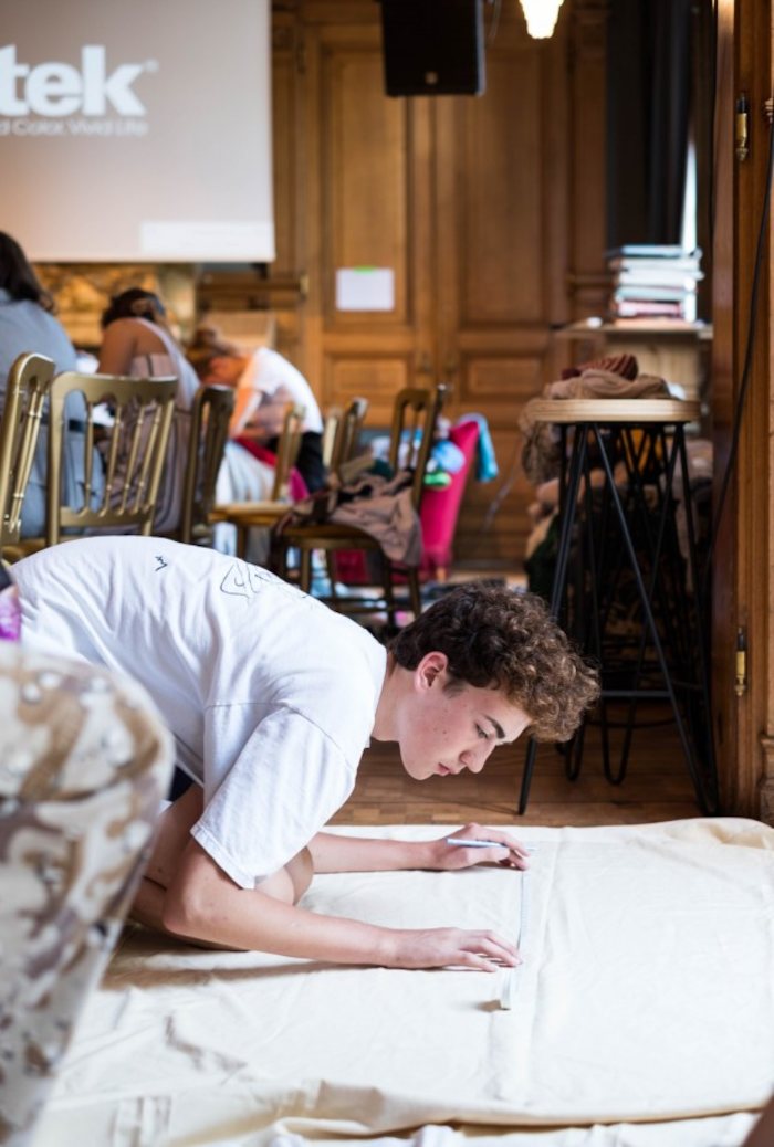 Jongen creëert zijn eigen kledij op zomerkamp in België.
