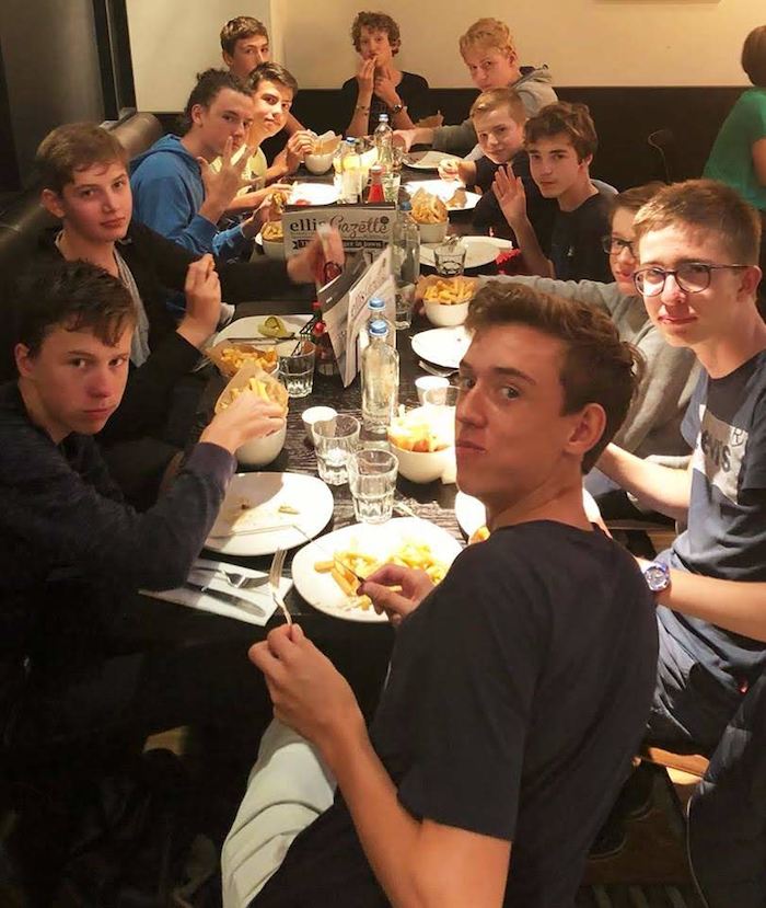 Jongens eten samen op zomerkamp.