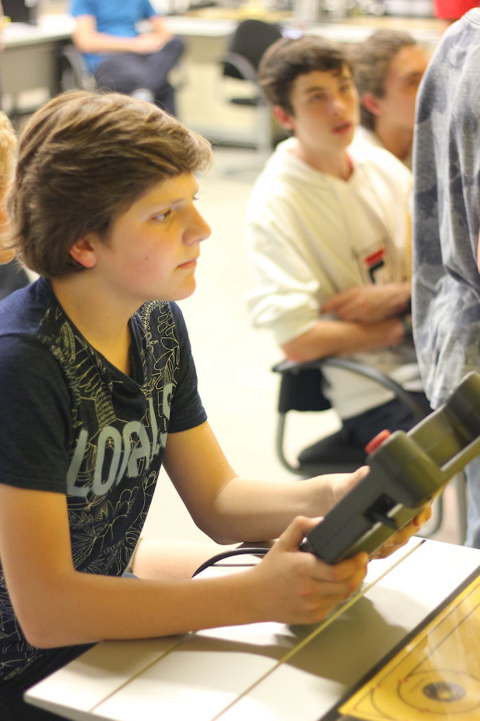 Jongeren bezoeken de robotfabriek op zomerkamp in België.