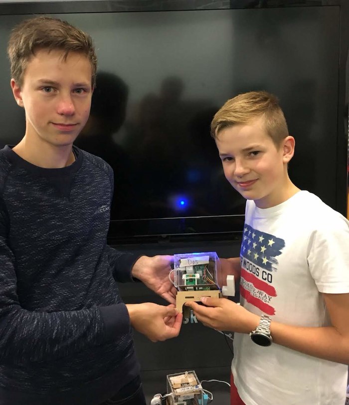 Jongens tonen samen hun robot tijdens het zomerkamp.
