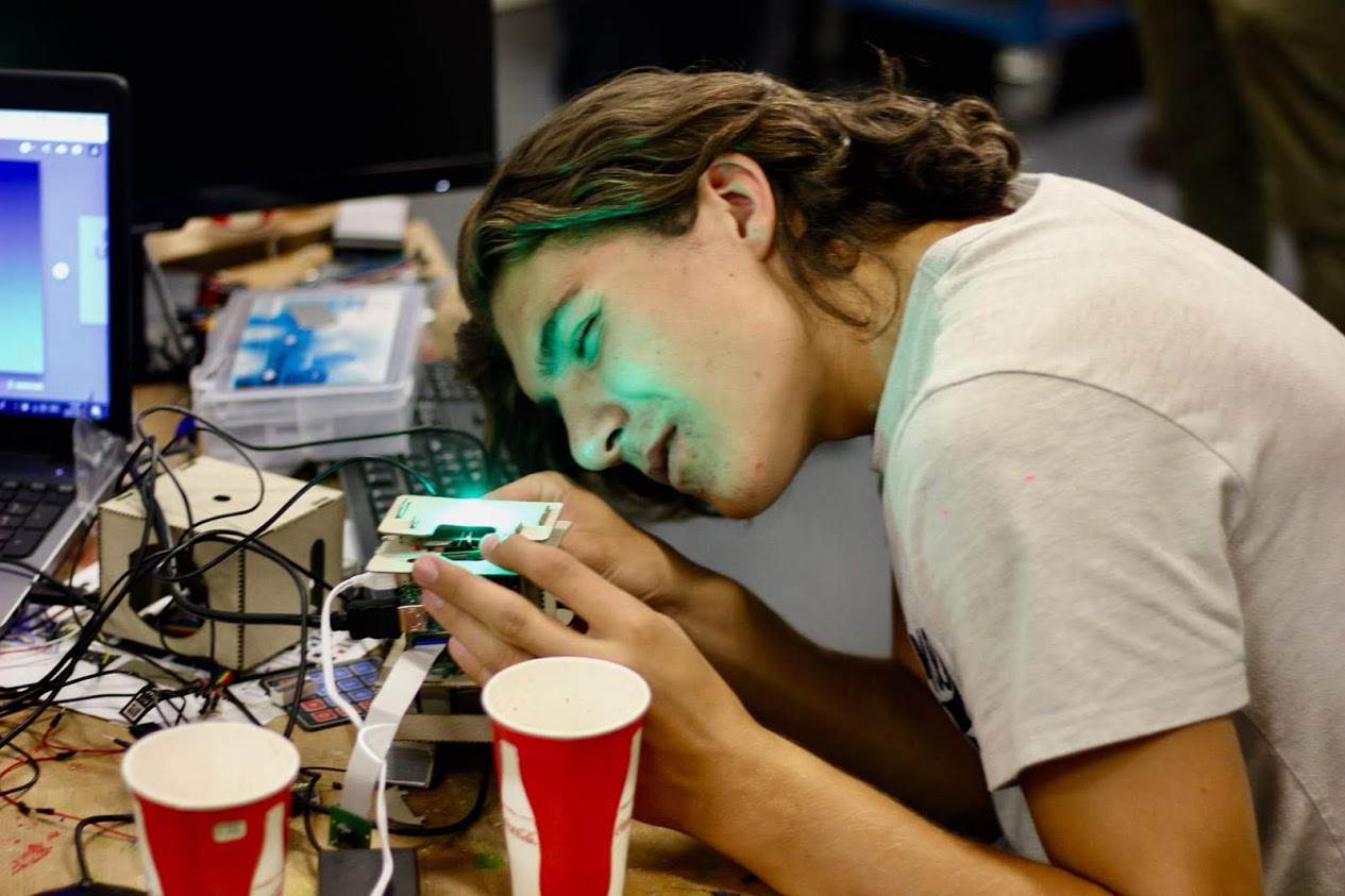 Jongen bouwt een robot op zomerkamp in België.