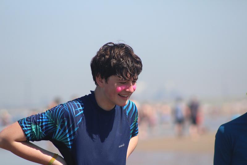 Jongen lachend op de foto tijdens een surfkamp Zandvoort