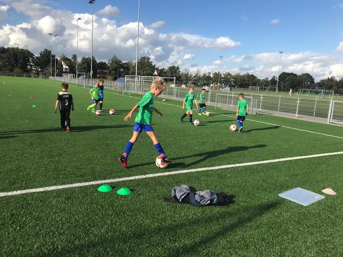 Jongens aan het voetballen op sportkamp West-Vlaanderen