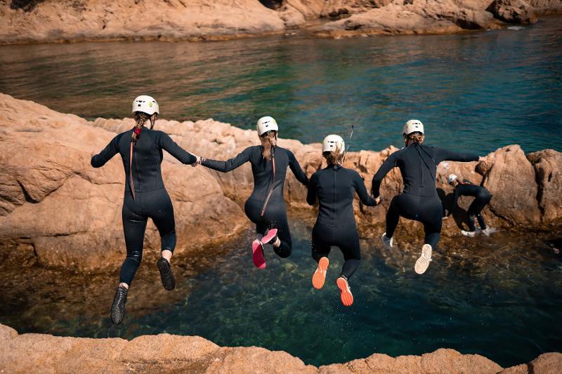 Meiden doen aan kliffspringen op de jongerenreis Spanje