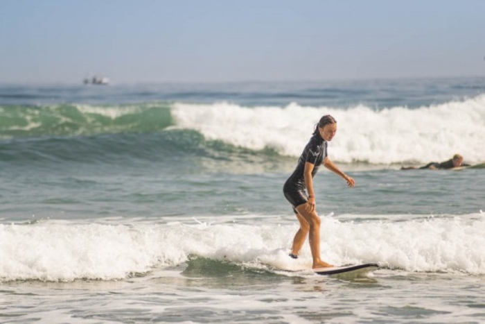 Meisje surft met haar board over de golven in het buitenland.