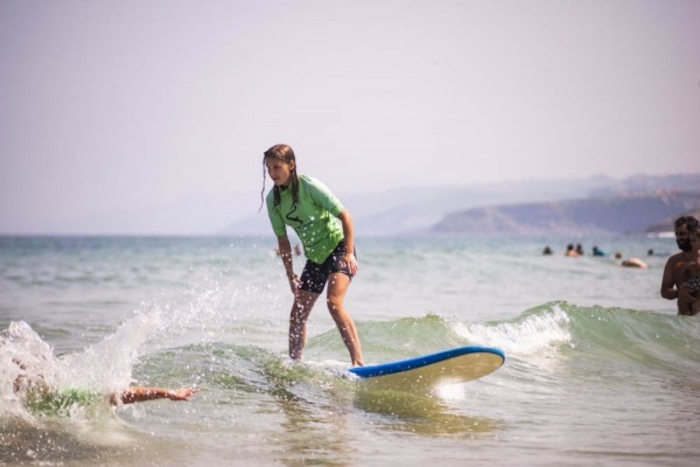 Een meisje staat op een surfboard op jongerenreis.