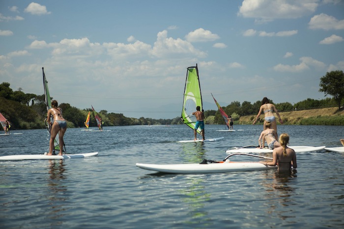 Jongeren leren windsurfen op reis in het buitenland.