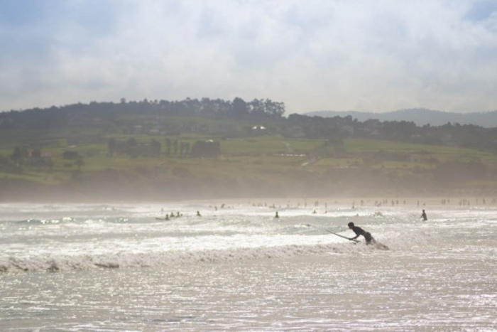Surfers op jongerenreis in de zee.