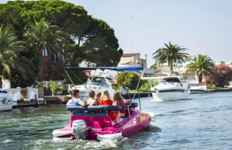 een bootje met toeristen vaart over het kanaal op zomerkamp spanje watersportvakantie