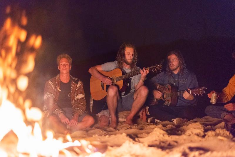 rond het kampvuur tijdens een surfkamp 16 jaar