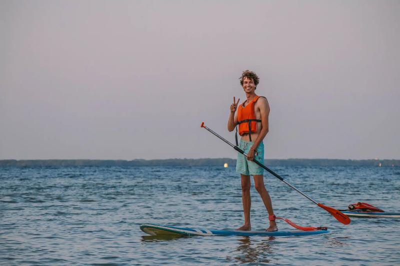 jongen die op een board staat tijdens surf vakantie 