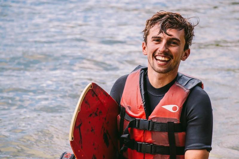 een jongen aan het lachen tijdens een surfkamp Frankrijk 16 jaar