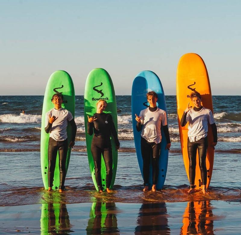 Jongeren met een surfboard op surfvakantie Spanje