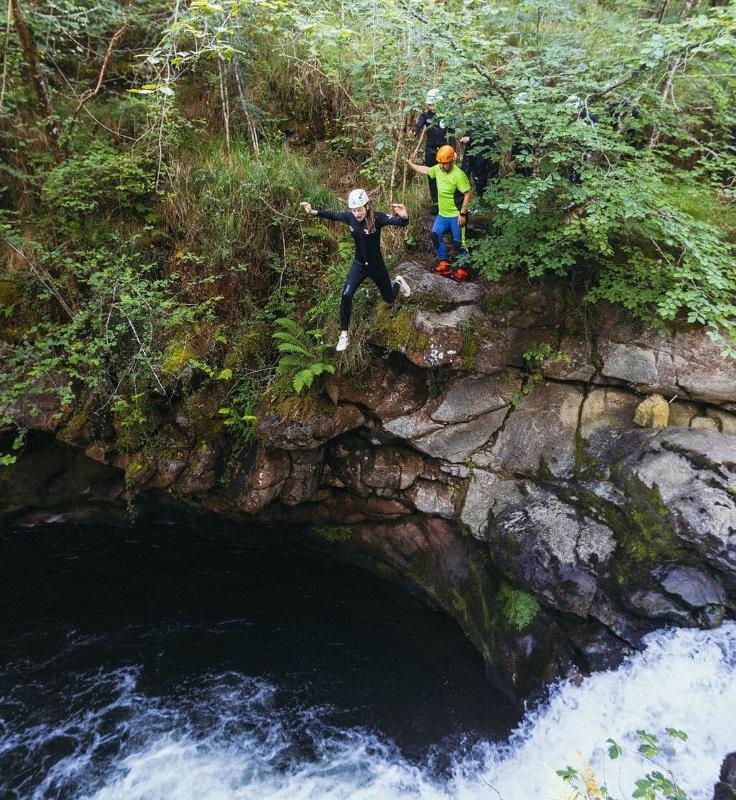 Meisje springt van rots op een surfvakantie Spanje