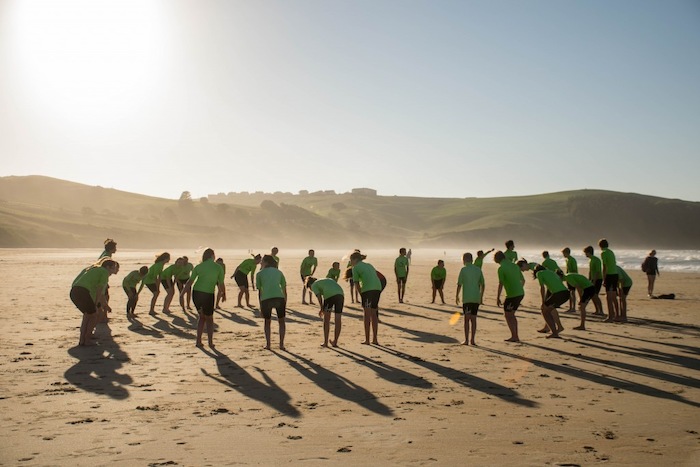 Jongeren bereiden zich op het surfen voor op het strand tijdens een jongerenreis spanje surfkamp