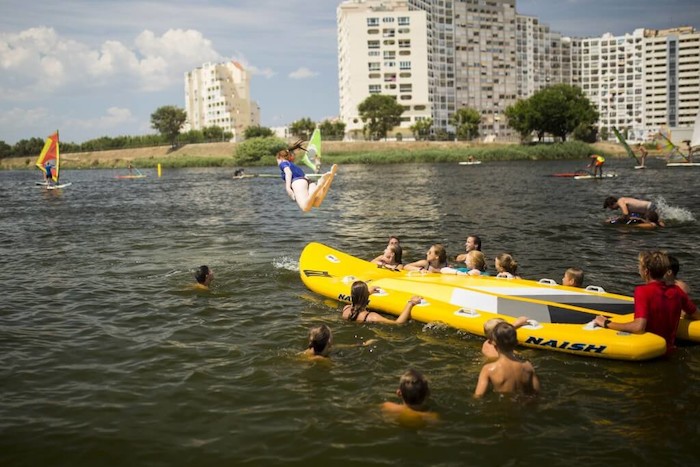 Een meisje springt van een sup op watersport vakantie in Spanje.