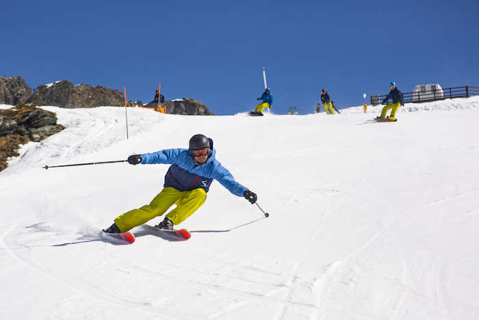 Deelnemer paaskamp glijdt op ski's van een besneeuwde berg