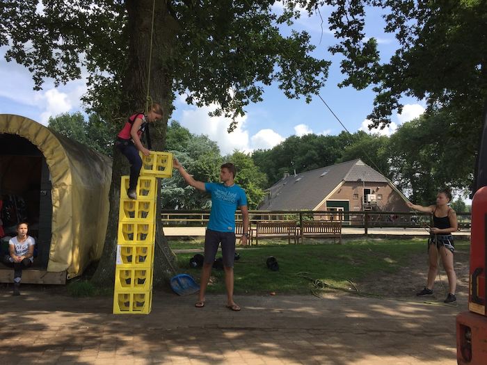 Deelnemers zijn bakken aan het stapelen tijdens een survivalkamp