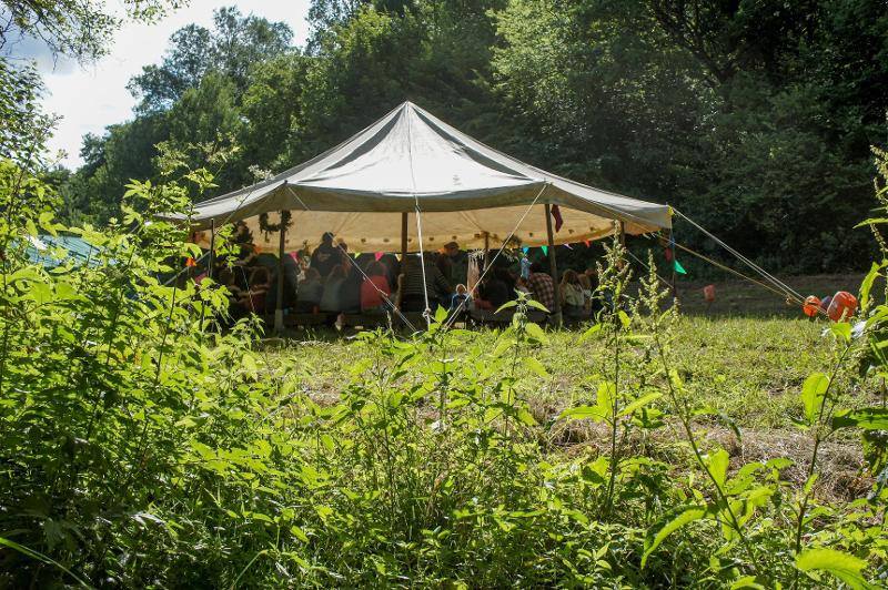 Kinderen zitten verzameld in een grote tent op survivalkamp Nederland