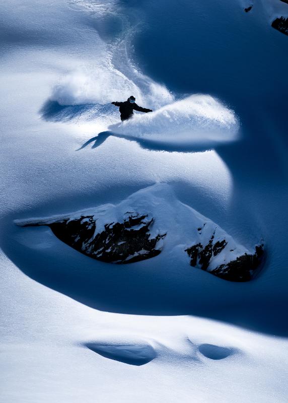 Een snowboarder in de sneeuw op jongeren skivakantie