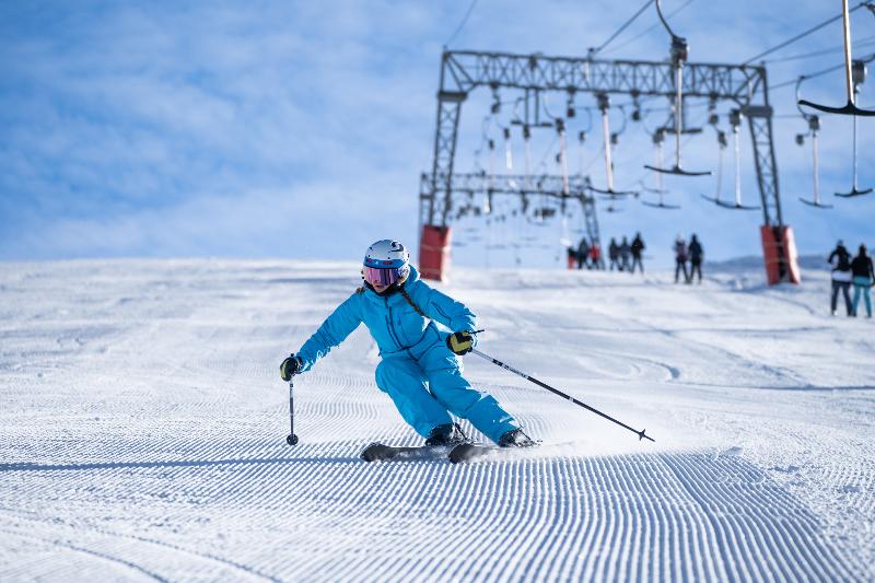 Een skiër met een blauw pak op de skipiste op jongeren skivakantie