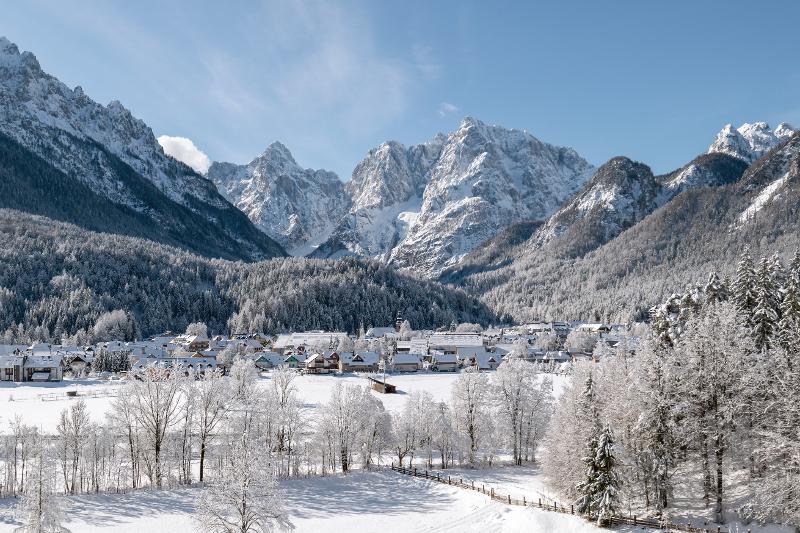 Een besneeuwd landschap met bergen op groepsreis skivakantie in Slovenië