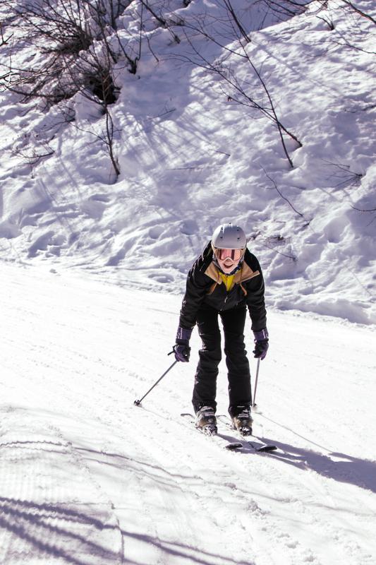 Een gehurkte skiër in de sneeuw op groepsreis skivakantie
