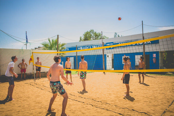 Jongeren spelen beachvolley in zomerkamp Spanje