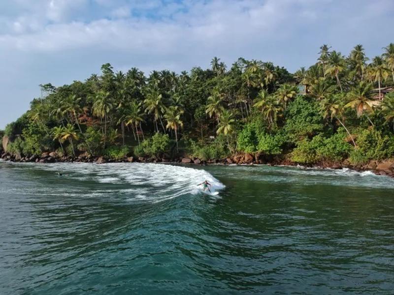 Een natuurlandschap met water en een golfsurfen omringd door palmbomen tijdens een groepreis Azië.