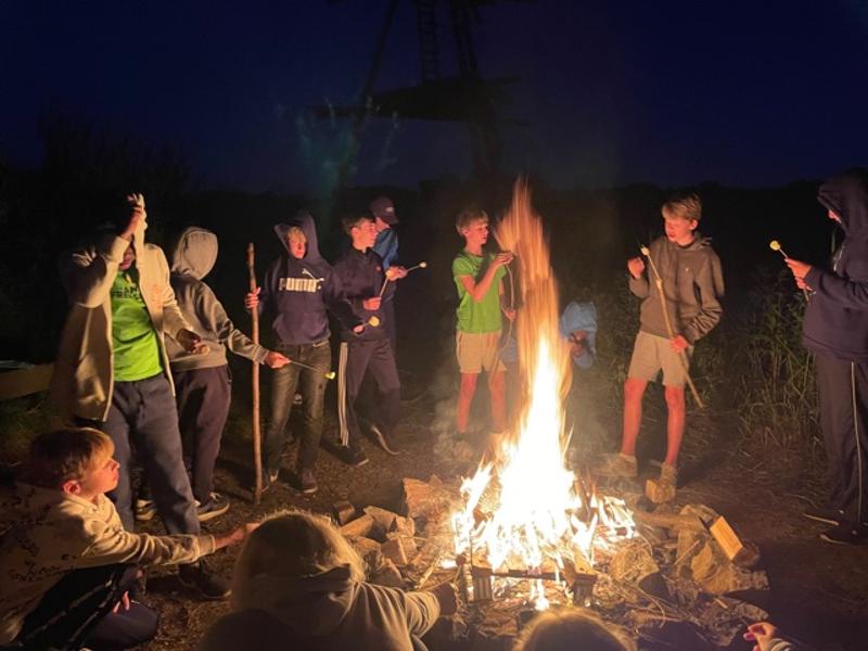 Kinderen rond het kampvuur op kinderkamp