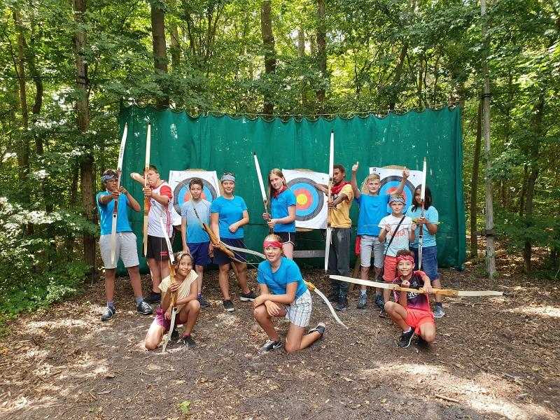 Kinderen poseren met pijl en boog op kinderkamp