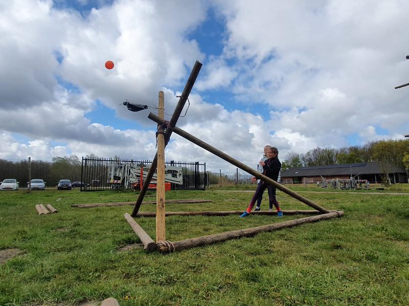 Kinderen staan naast houten constructie op kinderkamp